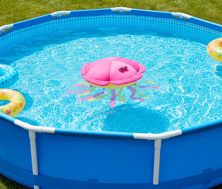 Ein blaues Aufstellbecken gefüllt mit Wasser. Darin befinden sich Schwimmreifen und ein pinkfarbener Tintenfisch als Wasserspielzeug.