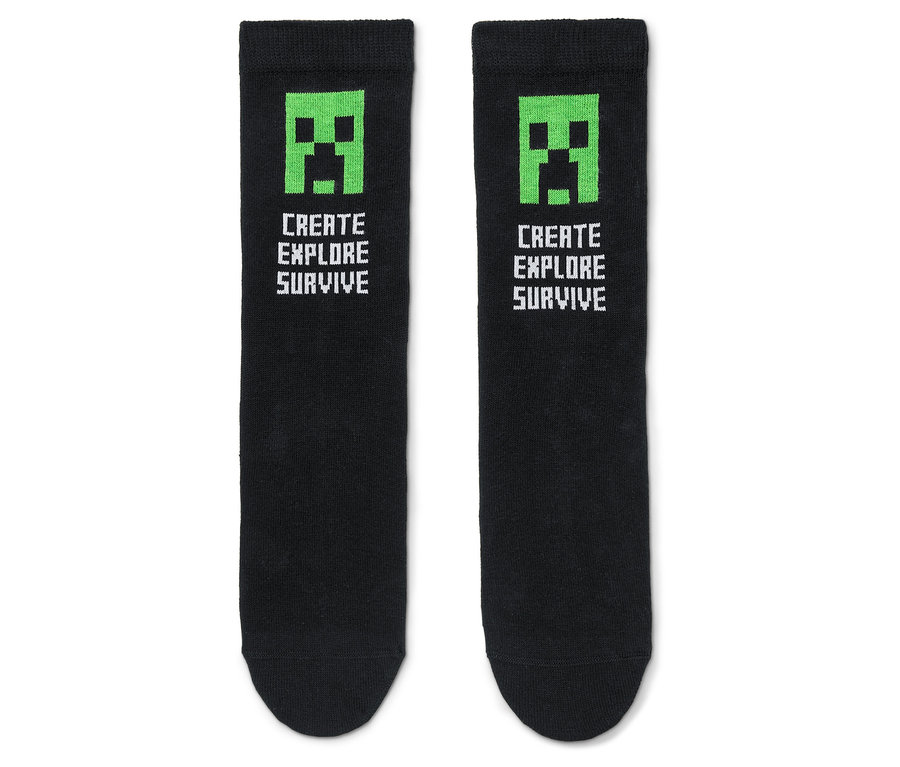 Zwei schwarze Socken mit grünem Minecraft-Creeper-Gesicht und dem Text "Create Explore Survive".