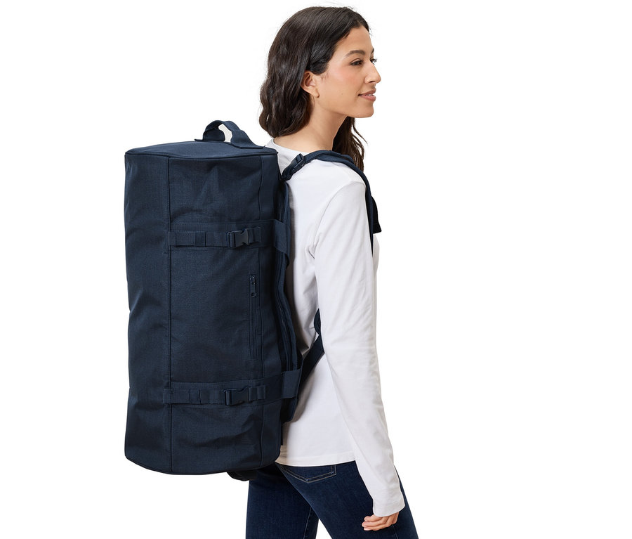 Frau trägt Reisetasche-und-Rucksack.