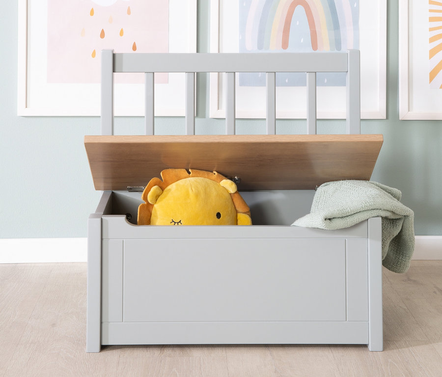 Eine offene Spielzeugtruhe mit einem Plüschlöwen und einer grünen Decke darin, dahinter drei Bilder an der Wand. Roba Kindertruhenbank »Woody« ist sichtbar.