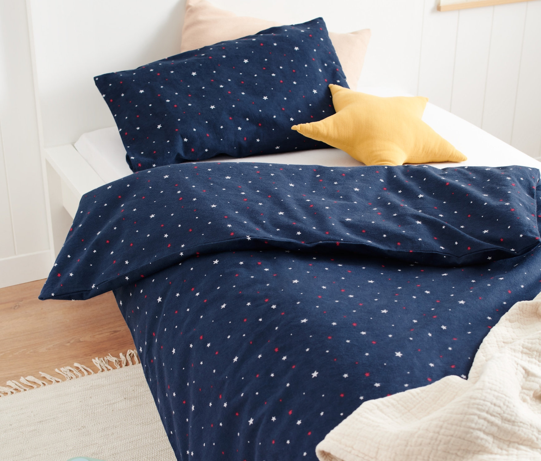 Kinder-Biber-Bettwäsche mit Sternen liegt auf einem Bett.