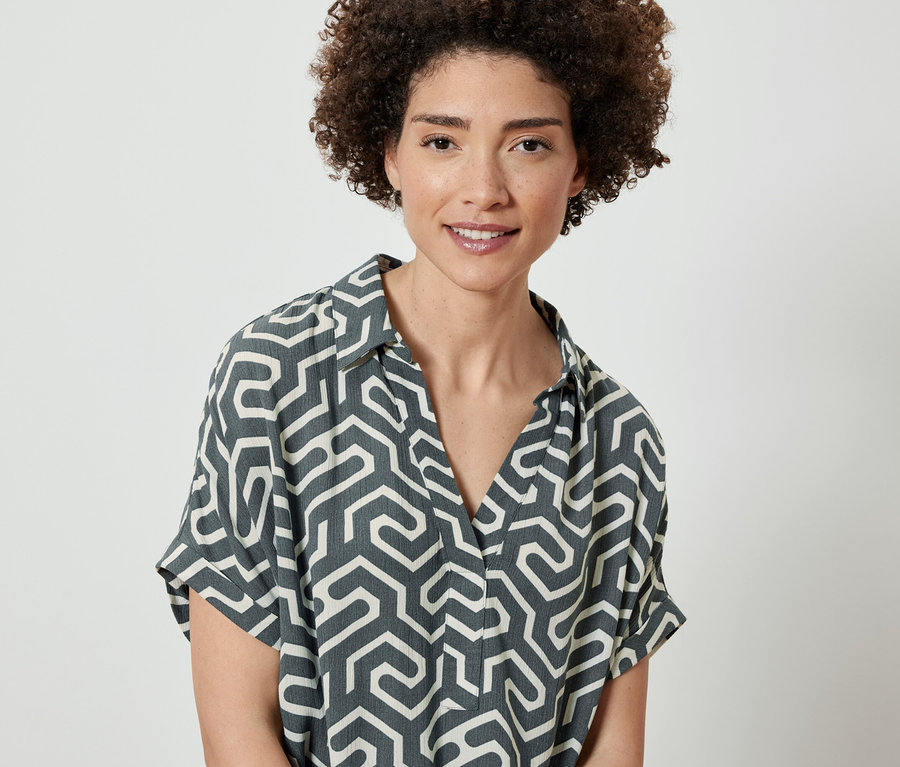 Frau trägt eine bedruckte Bluse.