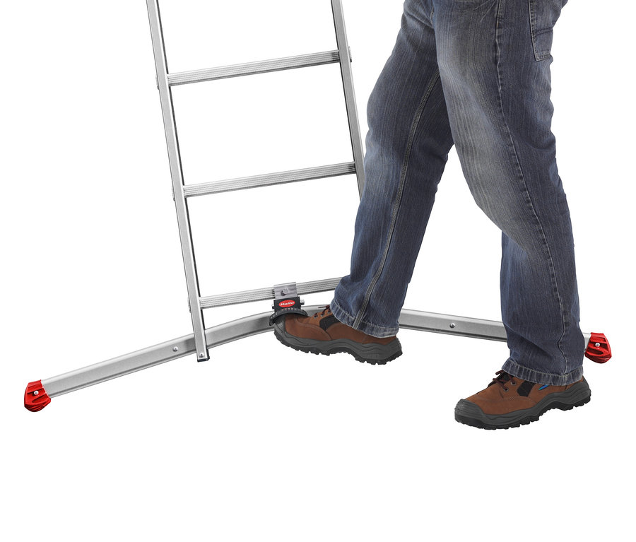 Mann in Jeans steigt auf eine silberne Trittleiter. Die Leiter hat rote Füße.