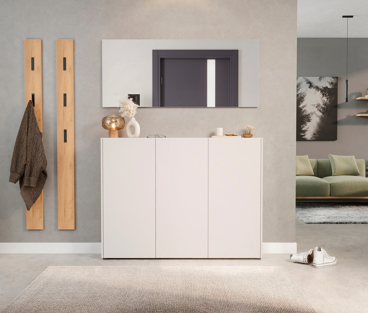 Flur mit weißem Schuhschrank unter rechteckigem Spiegel, zwei Holzgarderobenpaneelen und beigem Teppich.