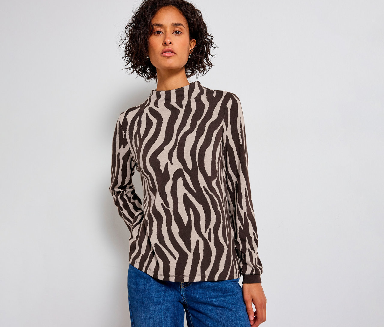 Frau trägt ein Street One Jacquard-Shirt mit Zebramuster und blaue Jeans.