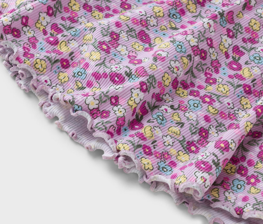 Nahaufnahme eines lila, gerippten Stoffes mit Blumenmuster.