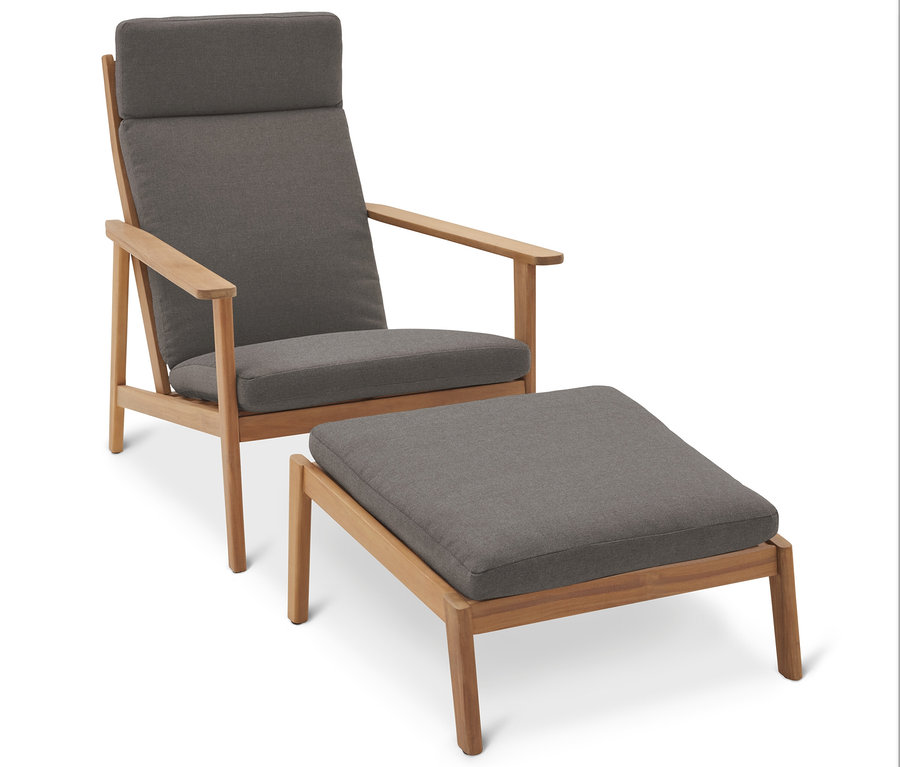 Ein grauer Sessel mit einem passenden Ottomanen auf einem weißen Hintergrund.