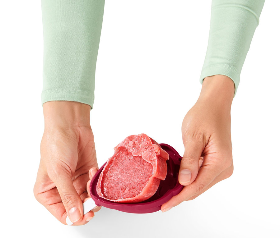 Hände halten rotes Eis in 4 Eisformen.