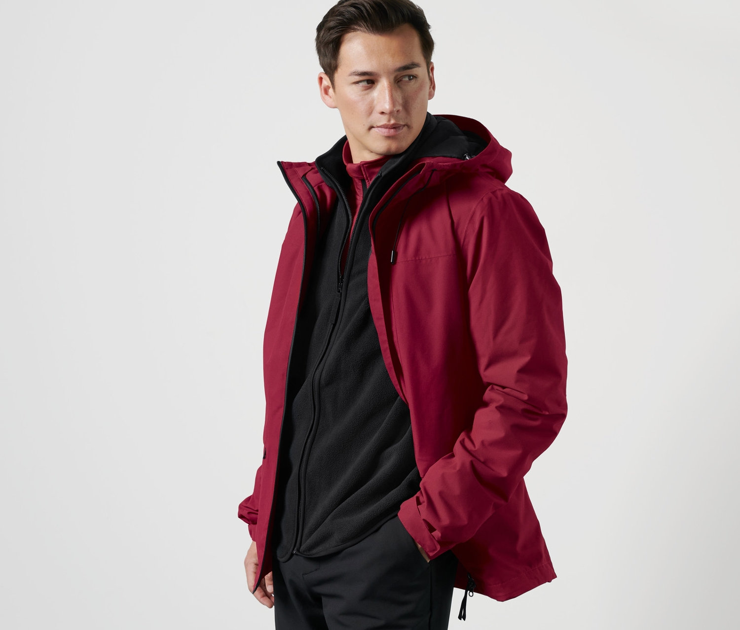 Mann posiert in Outdoorjacke mit Weste.