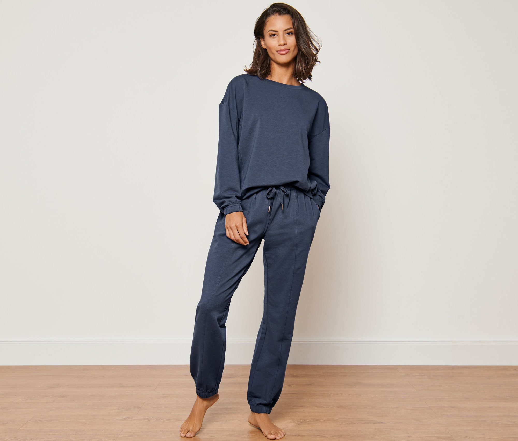 Frau posiert in einem dunkelblauen Hausanzug.