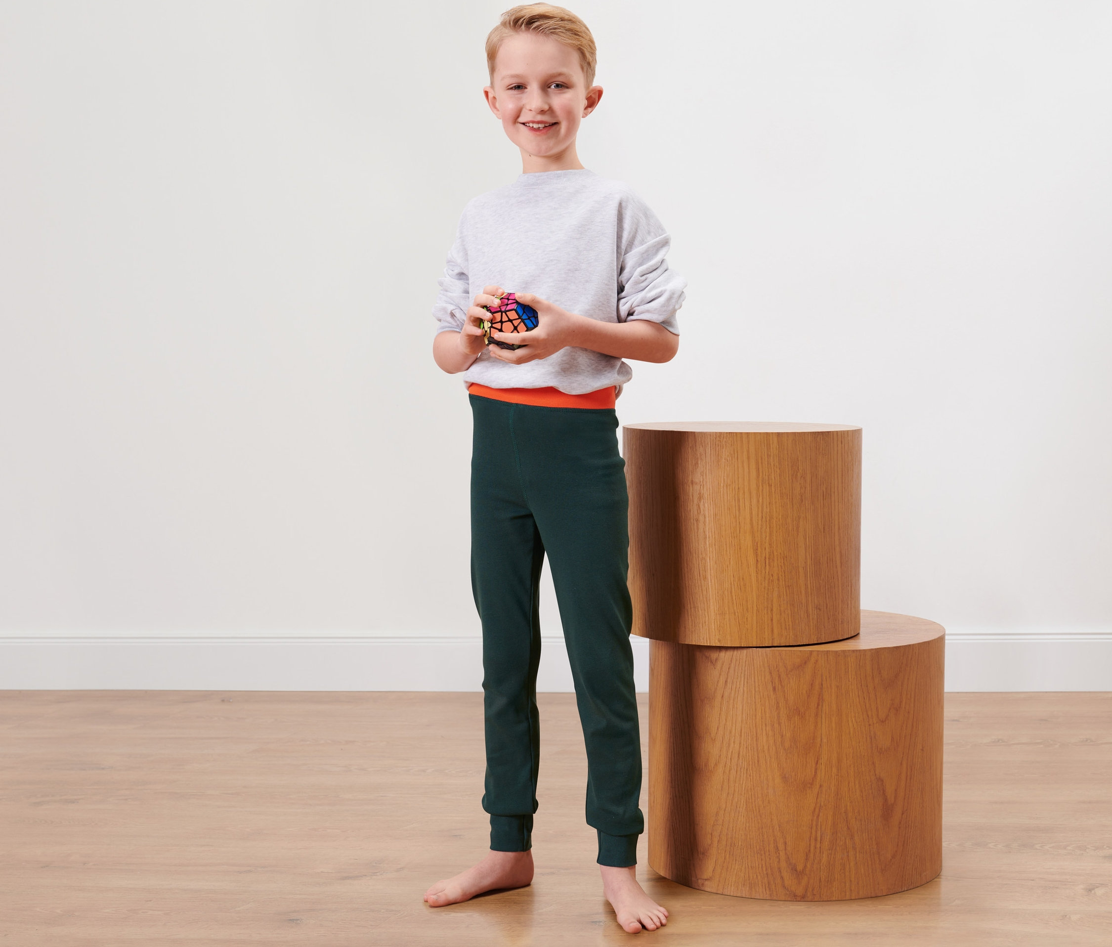 Junge hält einen Zauberwürfel und trägt 2 lange Kinder-Winterunterhosen.