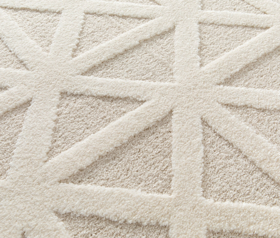 Detailaufnahme eines cremefarbenen Teppichs »Cosmo« Geo mit geometrischem Muster.