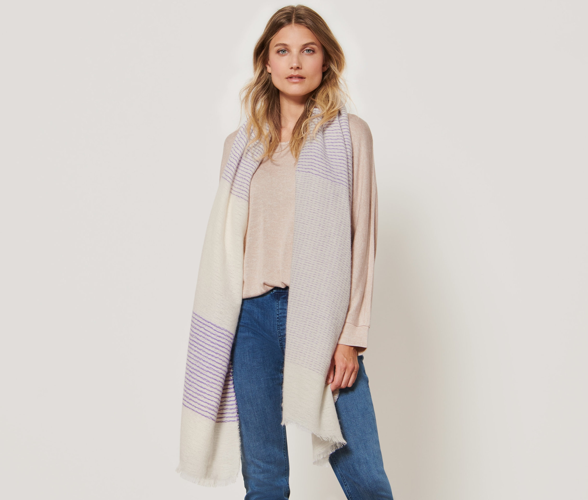 Frau posiert mit einem gestreiften Webschal.