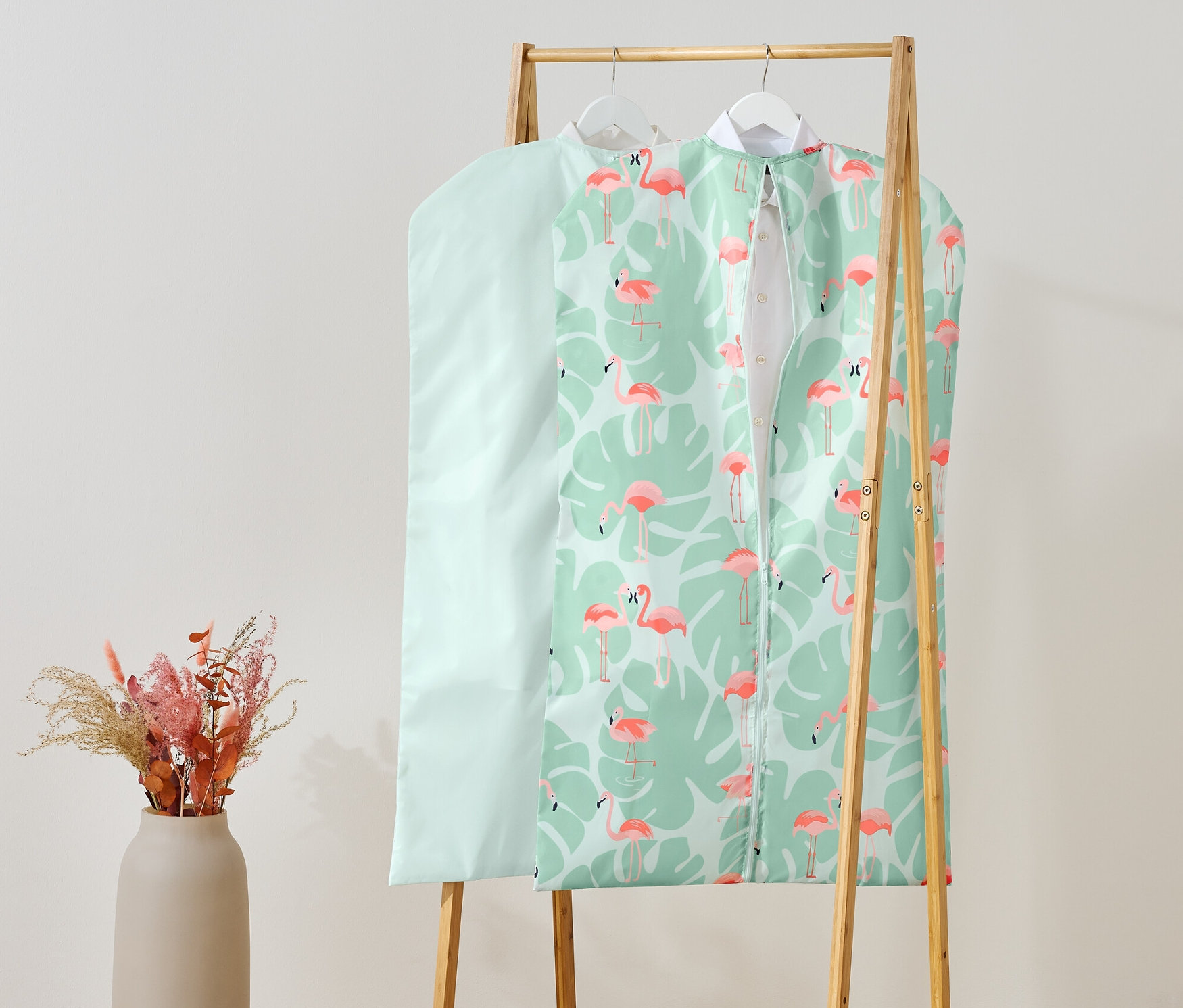 Zwei Kleiderschutzhüllen hängen auf einem Kleiderständer.