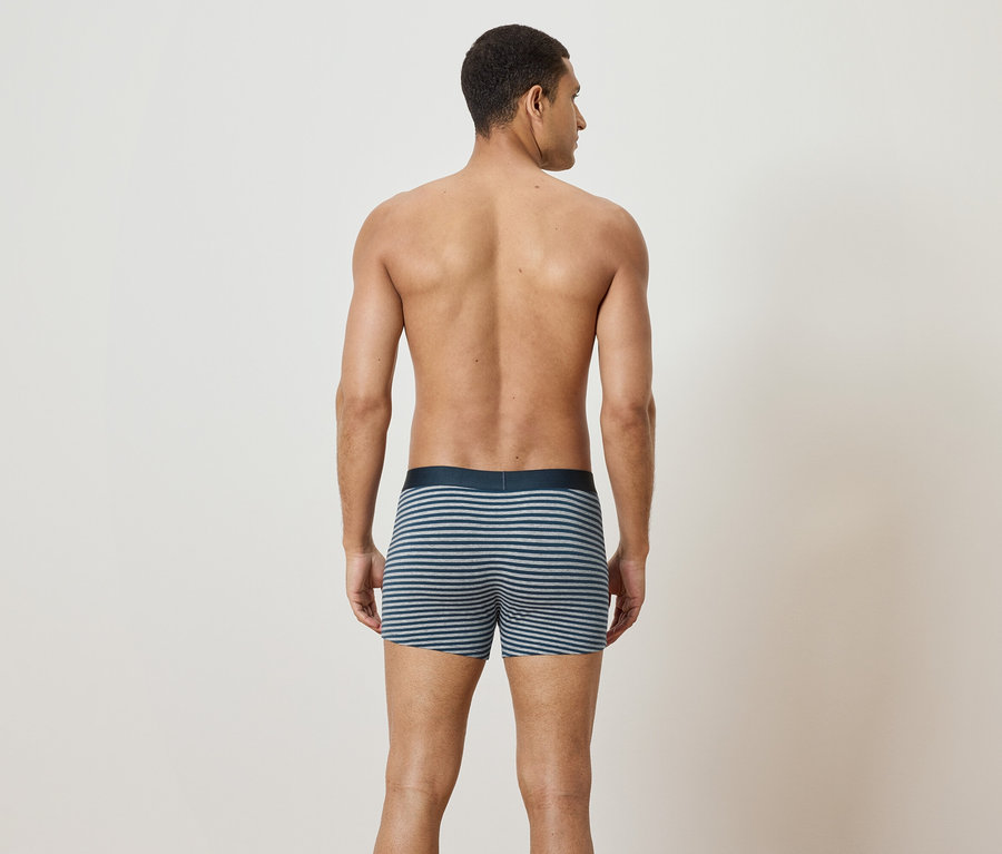 Mann von hinten trägt gestreifte Boxershorts.