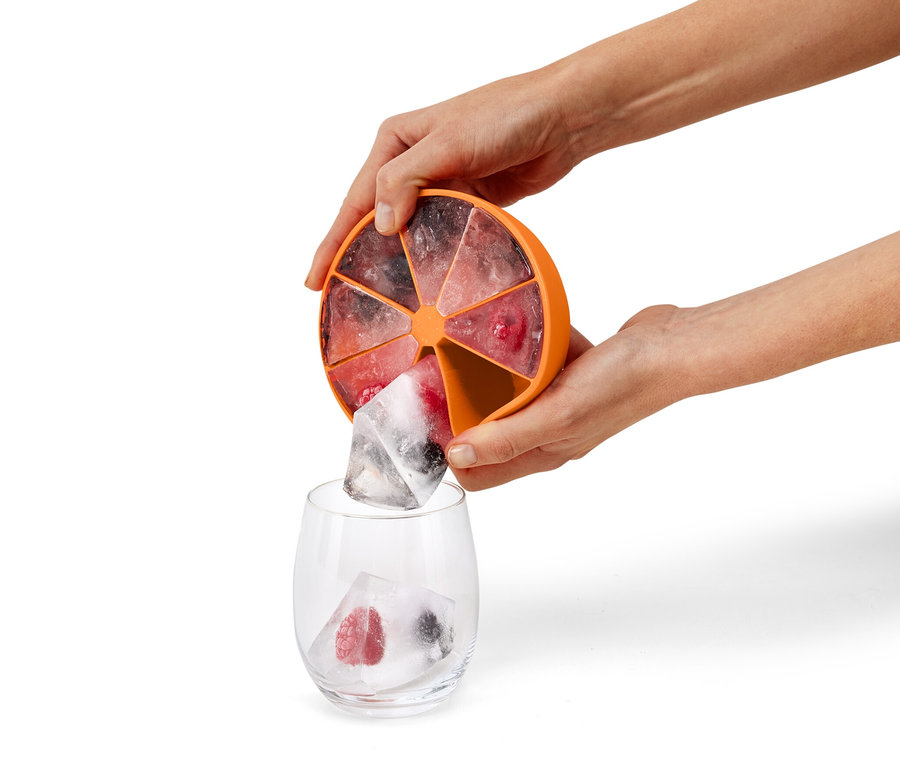 Frau gießt Eiswürfel aus dem XL-Eiswürfelbereiter in ein Glas.