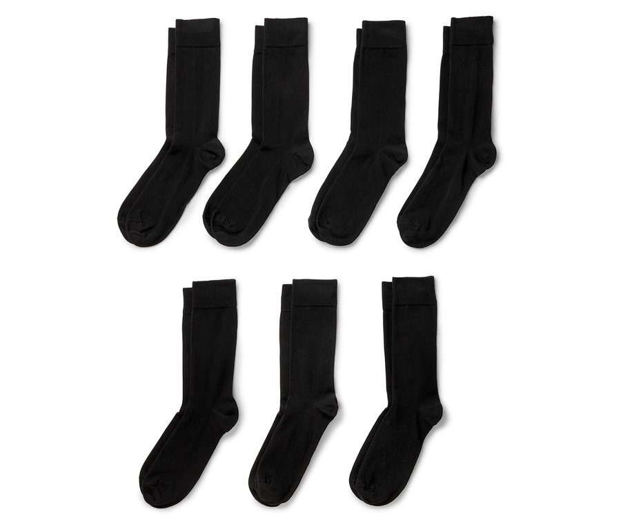 Sechs schwarze Socken liegen auf einem weißen Hintergrund.