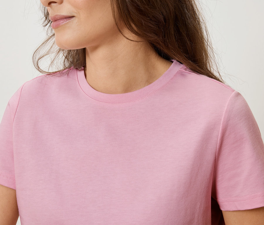 Nahaufnahme einer Frau, die ein rosa T-Shirt trägt.