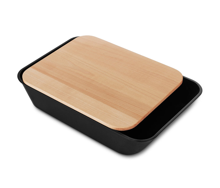 Ein Holz-Schneidebrett liegt auf einem schwarzen Behälter.