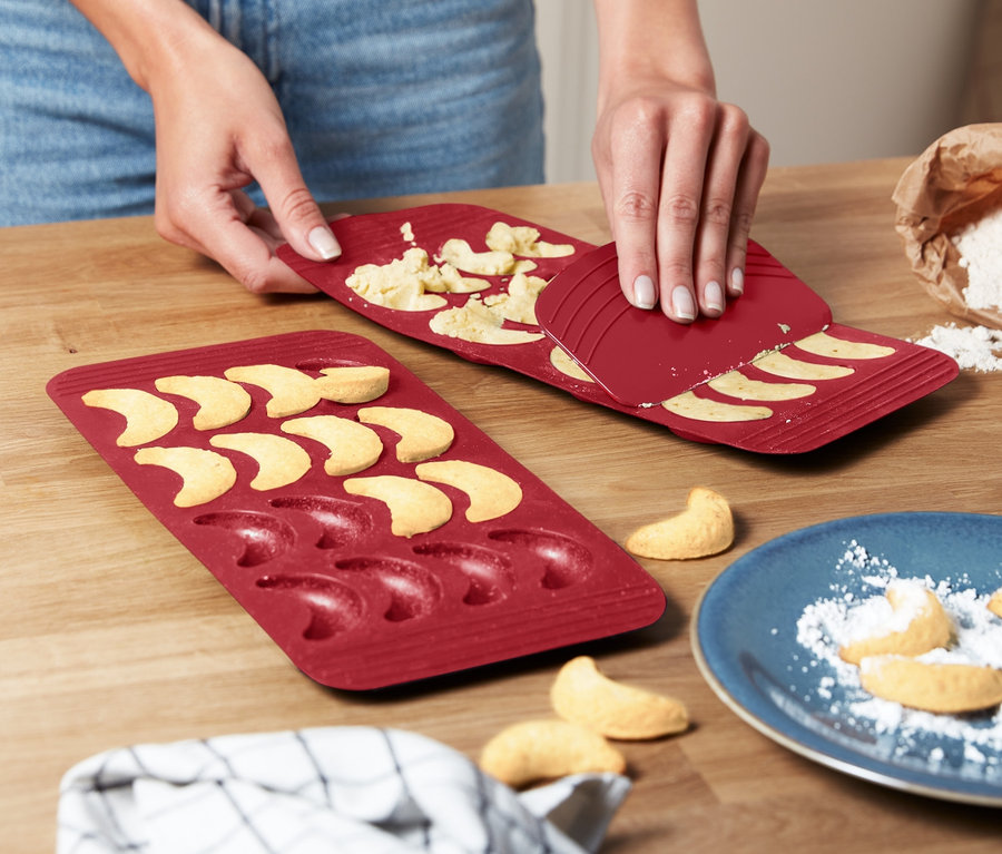 Frau löst Vanillekipferl aus 2 Vanillekipferl-Backmatten.