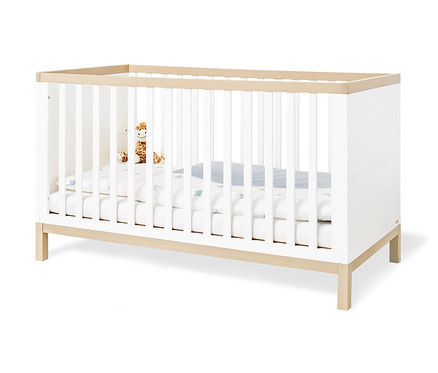 Ein Kinderbett mit weißen Stäben und einem Holzrahmen. Im Bett liegt eine weiße Decke mit blauen Sternen und eine Plüschgiraffe. 3-teiliges, großes Pinolino Set »Light« breit.