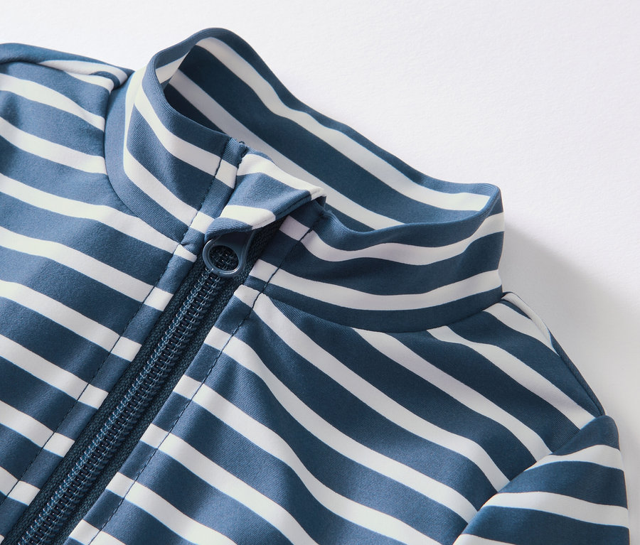 Detailansicht eines blau-weiss gestreiften Baby-Einteilers mit UV-Schutzfaktor 80 und Reissverschluss.