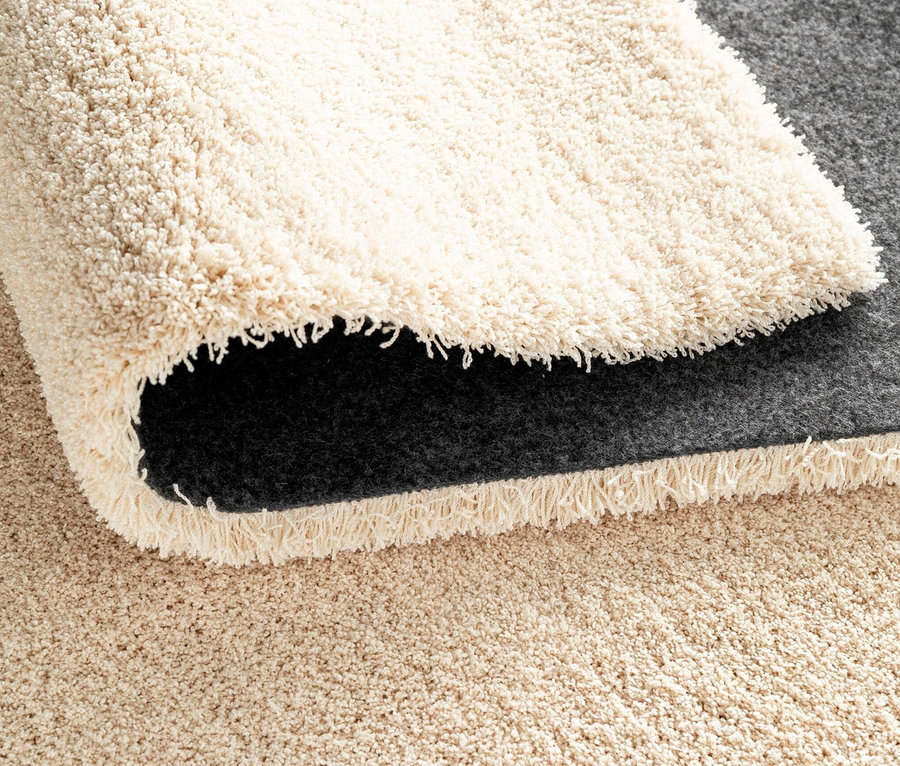 Detailansicht eines wollweißen Teppichs »Mellow«.