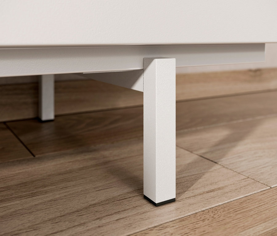 Detailaufnahme eines weißen Sideboards mit Bein auf einem Holzboden.
