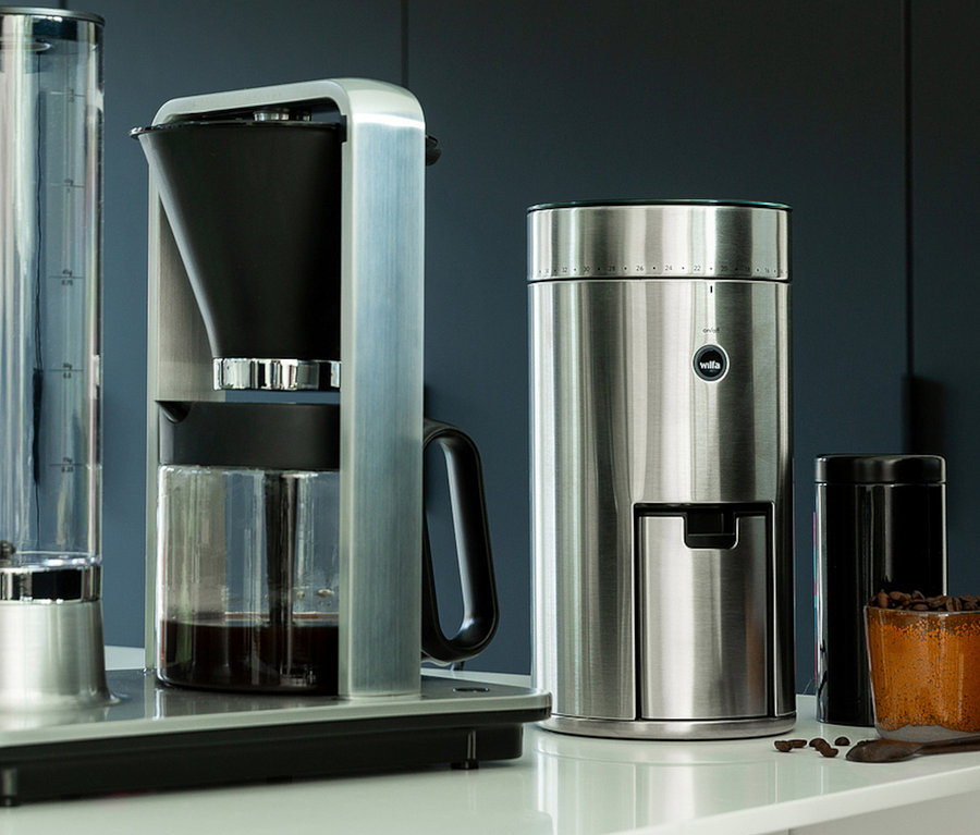 Silberne Kaffeemaschine und Wilfa Kaffeemühle »Svart Uniform« auf einer weißen Arbeitsfläche.