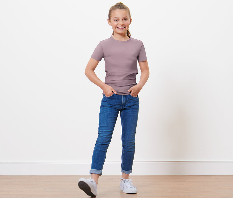 Mädchen posiert in 3 Kinder-T-Shirts.