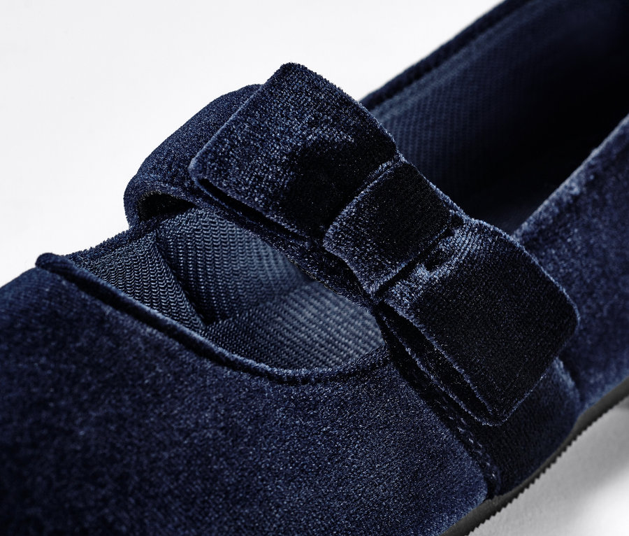 Detailaufnahme von Kinder-Samt-Ballerinas mit Schleife.