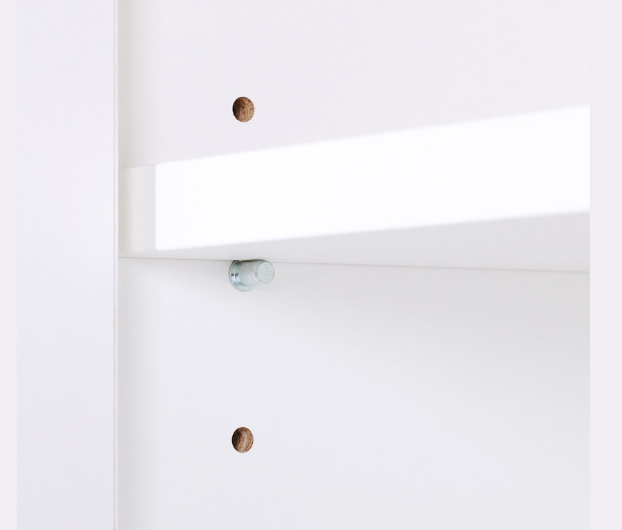 Detailansicht eines kleinen, weißen Büroschranks mit Furnierkante und Regal.