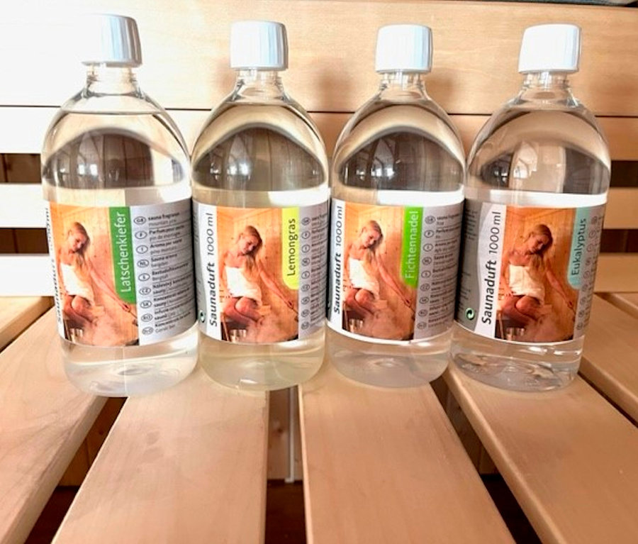 Vier Flaschen Karibu Sauna-Aufgusskonzentrat, je 1.000 ml, stehen auf einer Holzbank.