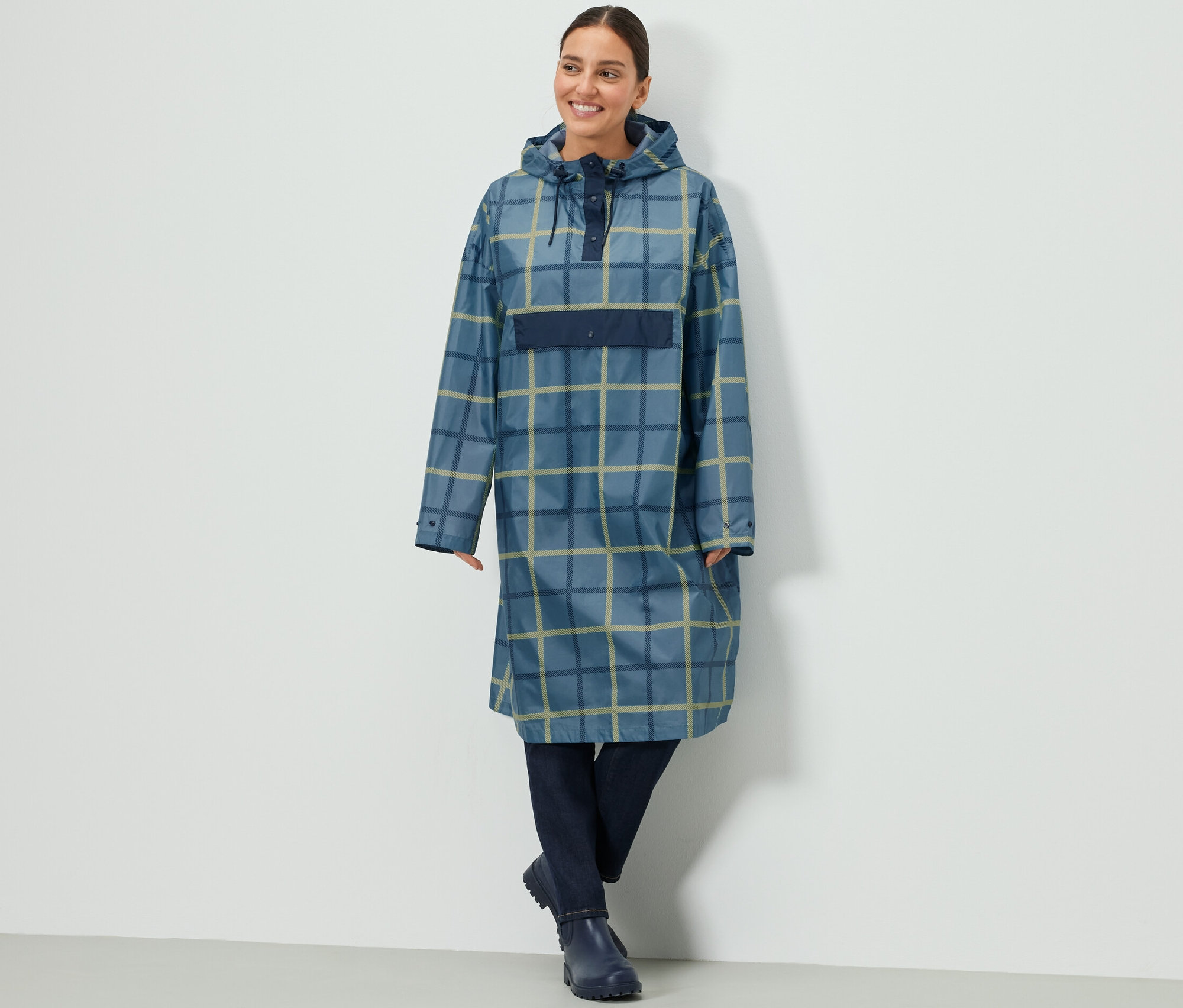 Frau trägt einen karierten Regenponcho mit Ärmeln.