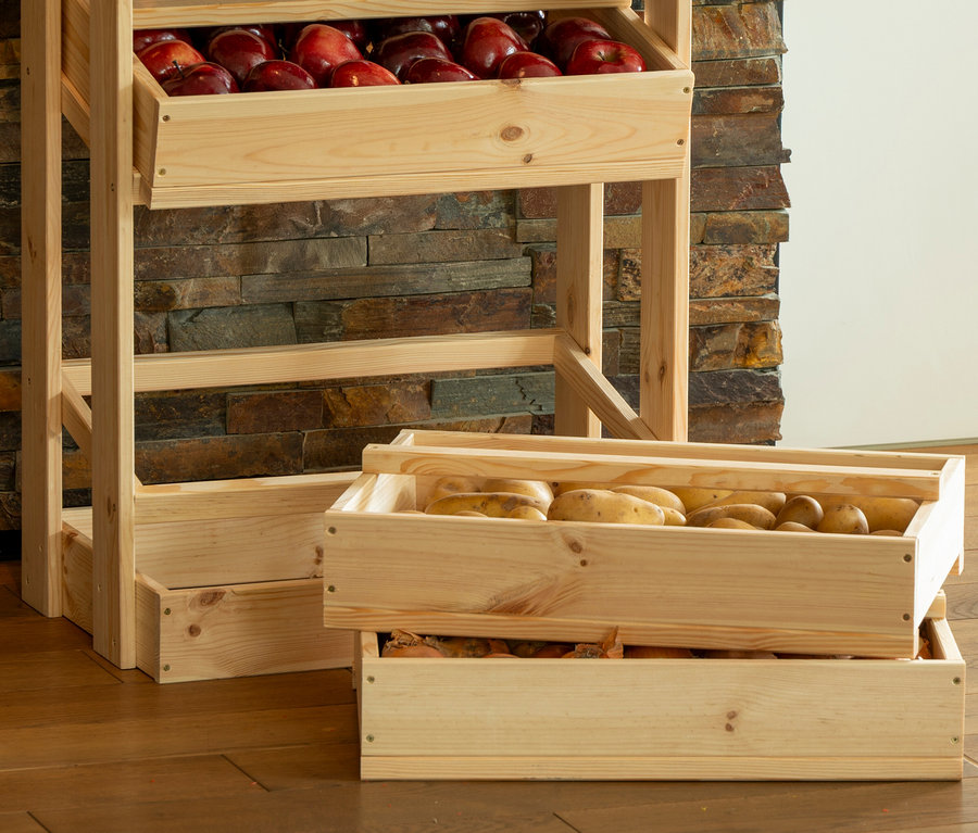 Hölzernes Vorratsregal mit zwei Regalen voller roter Äpfel und zwei Schubladen voller Kartoffeln.