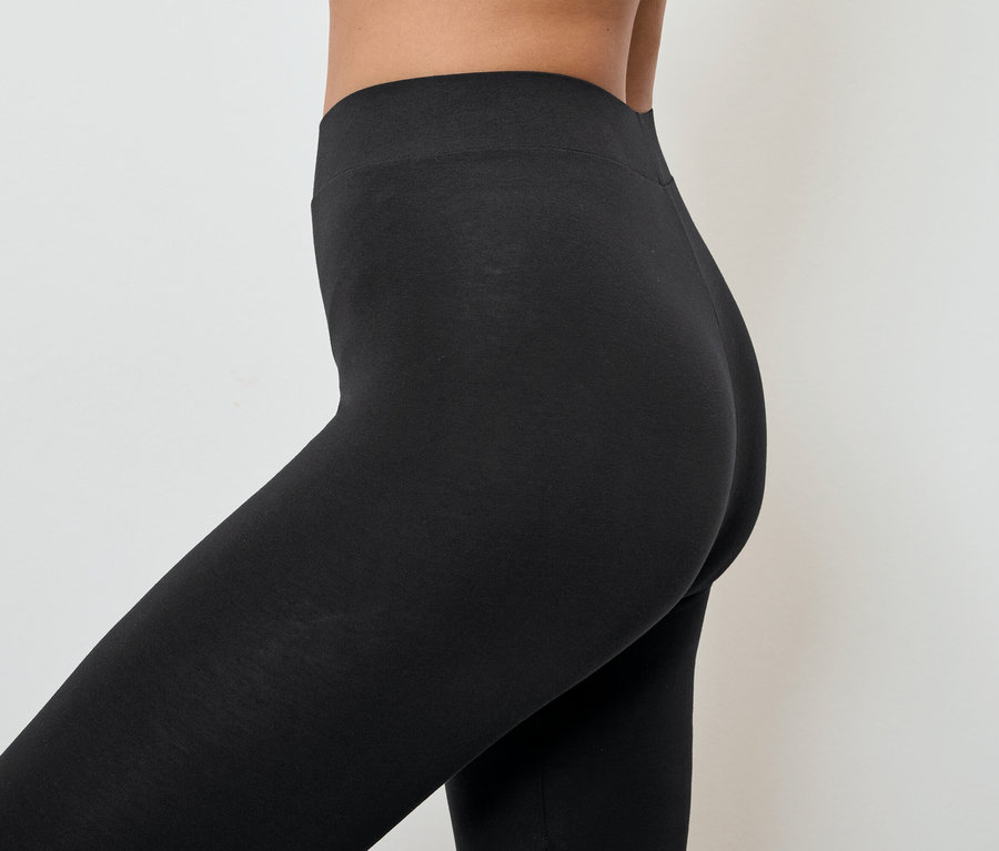 Detailaufnahme einer Frau, die schwarze Leggings trägt.