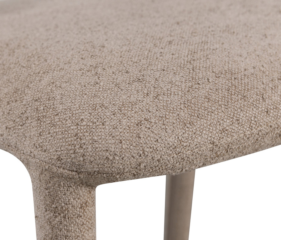 Nahaufnahme eines beigen, gepolsterten Stuhls mit Holzbeinen.