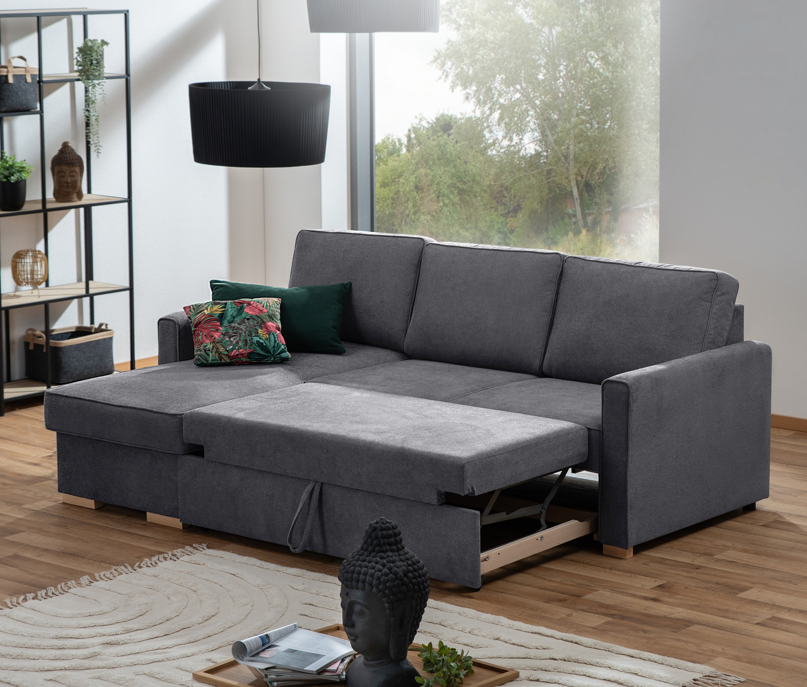 Graues Ecksofa mit Auszugsbett »NovaLounge« teilweise ausgezogen im Wohnzimmer.