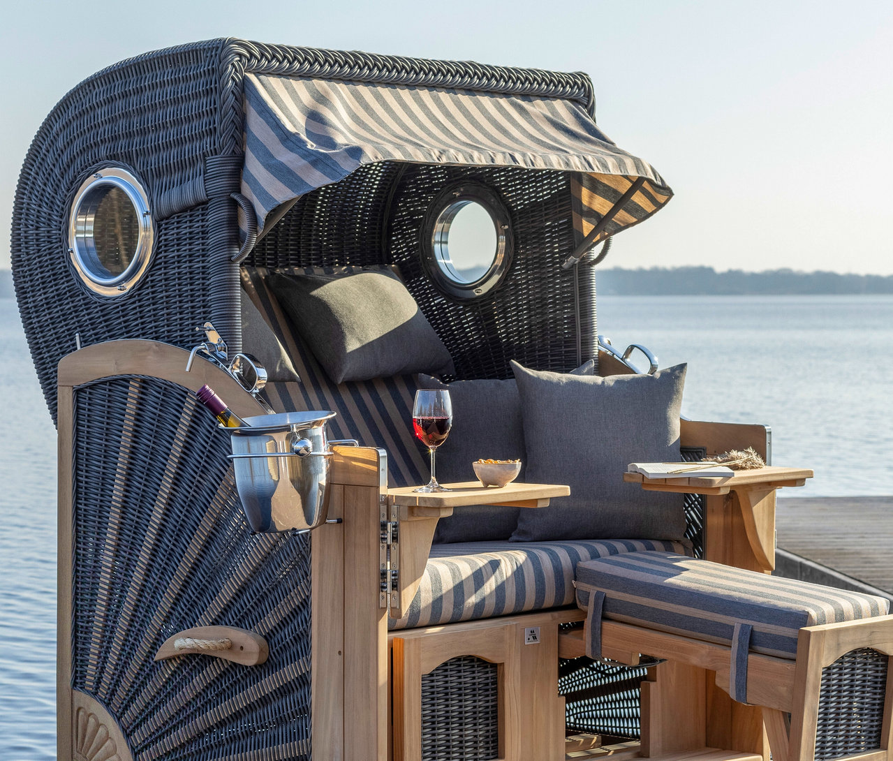 Strandkorb mit Getränken und Snacks am Wasser.