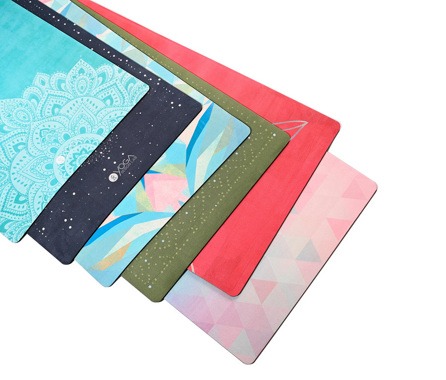 Detailaufnahme von sieben unterschiedlich gemusterten Yogamatten, die übereinander gestapelt sind.