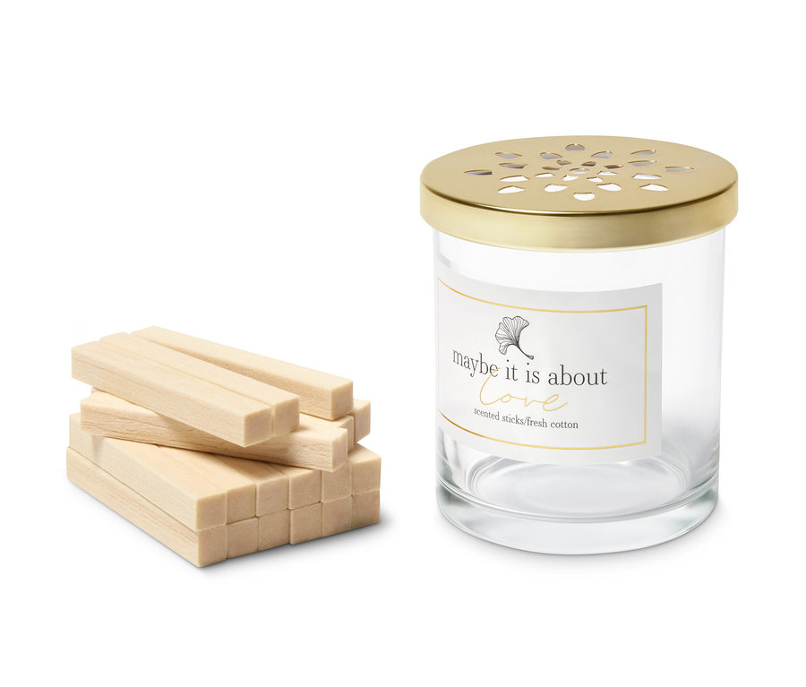 Ein Stapel Raumduft-Sticks, Baumwollfelder, neben einem Glasbehälter mit Deckel.