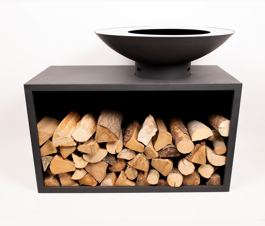 Eine liegende, schwarze RedFire Feuerschale »Onyx Classic Table«, 80 cm, auf einem schwarzen Holzgestell mit Holzscheiten.