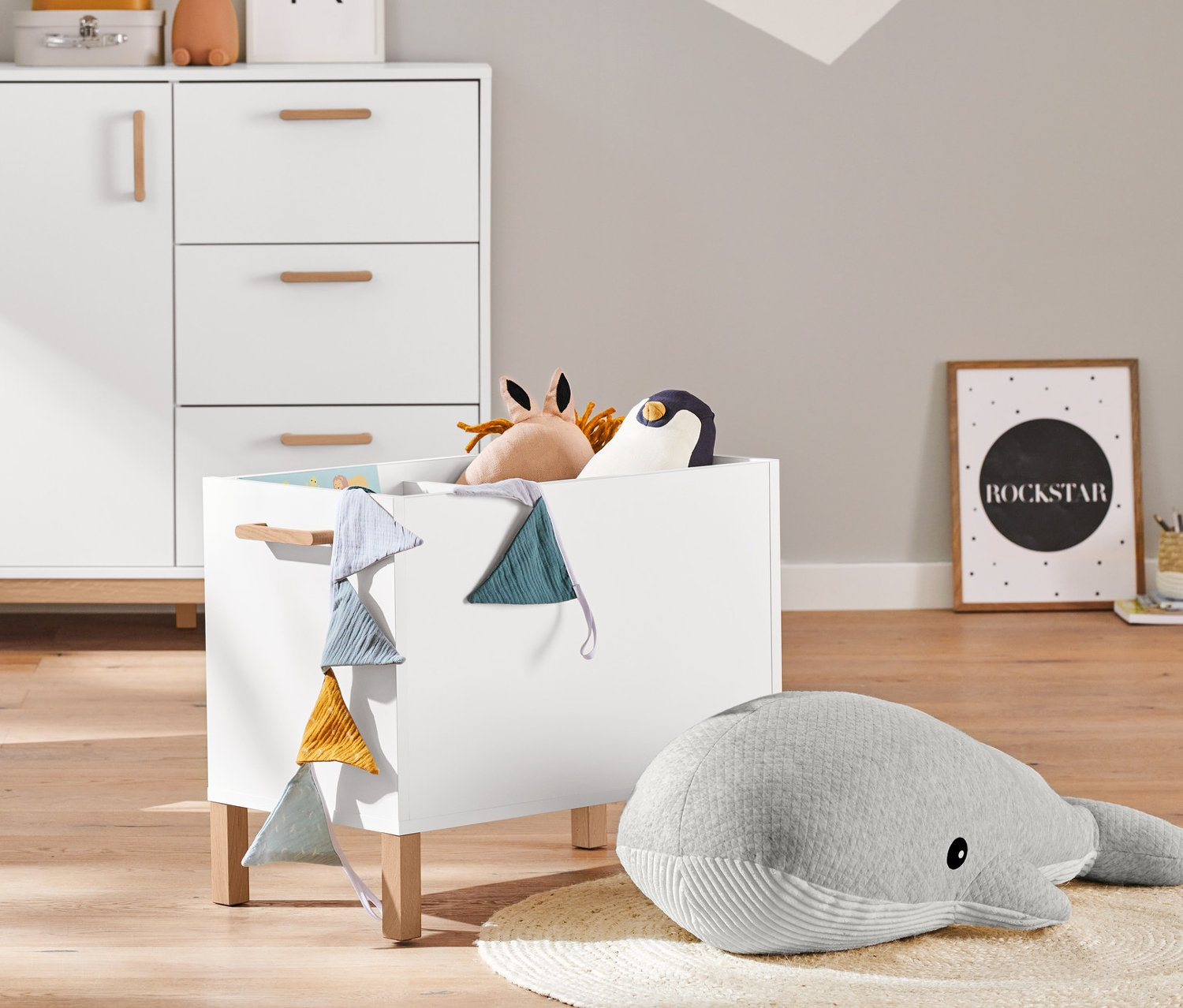 Einrichtung: Türkisfarbener Sessel mit Sternkissen, 2-in-1: Kommode und Kleiderschrank, 2 Aufbewahrungskörbe und ein Riesen-Plüschwal.