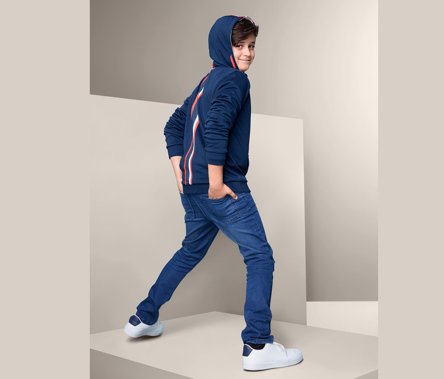 Ein Junge mit einer blauen Sweatjacke.