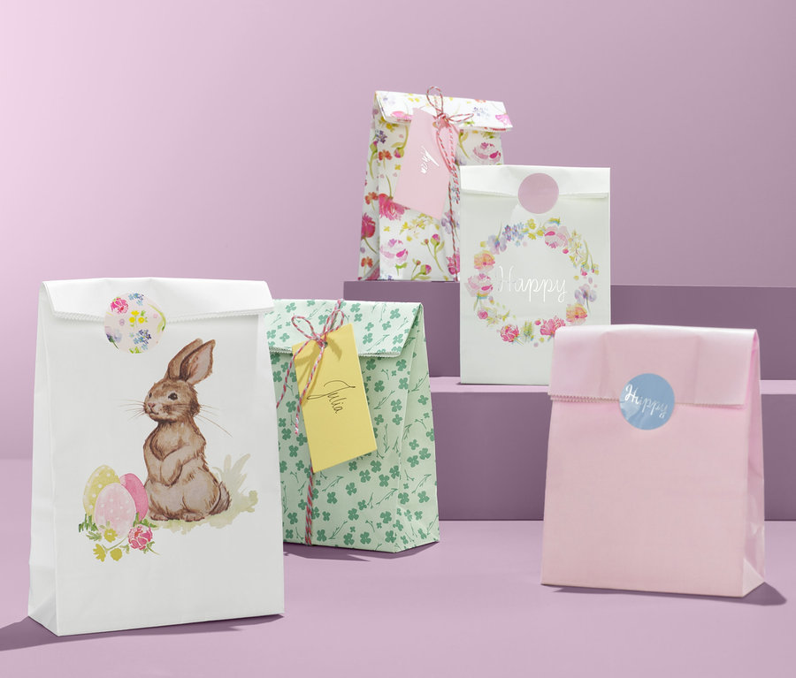 Vier Geschenktüten-Set mit Ostermotiven auf lila Hintergrund.