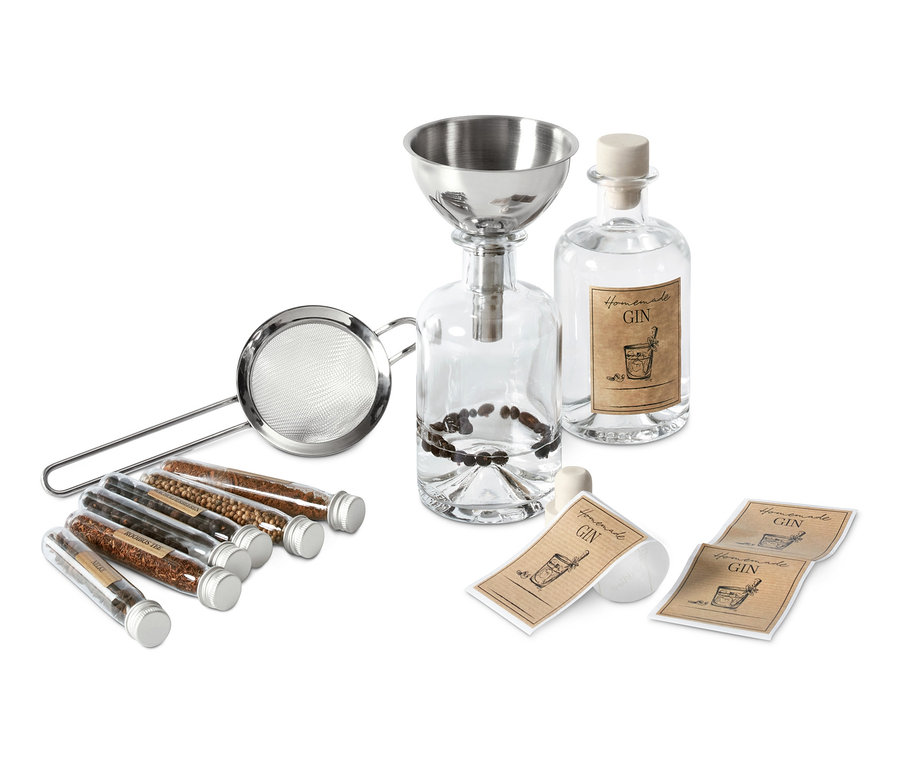Klare Flaschen, Gewürzröhrchen, Sieb und Trichter für ein Gin-Set zum Selbermachen.