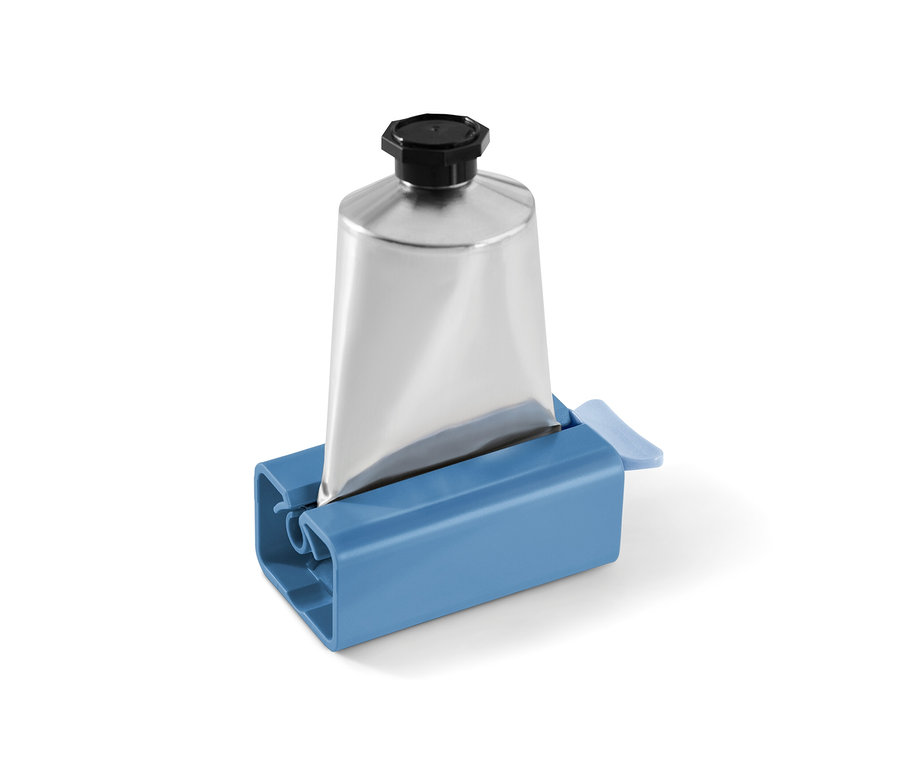 Silberne Tube in einem blauen Tubenpresser.