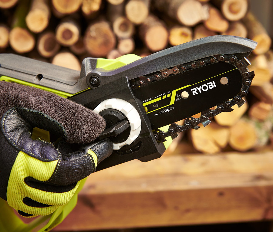 Eine Hand in einem Handschuh hält eine RYOBI 18 V One+ Brushless Akku-Einhand-Kettensäge.