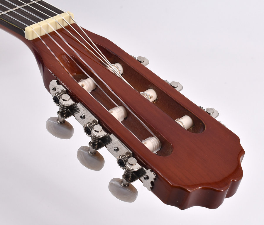 Detailaufnahme vom Kopf einer braunen Akustikgitarre mit Stimmwirbeln und Saiten. Voggenreiter VOLT Akustik Gitarren-Set 4/4.