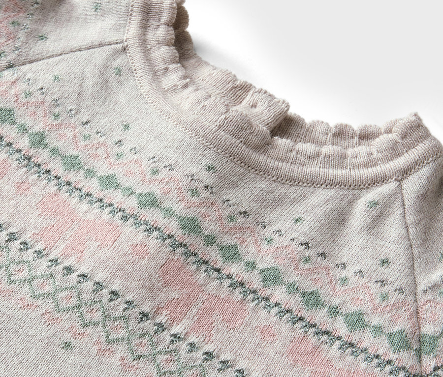 Detailansicht eines Pullovers mit rosa-grünem Muster und Rüschenausschnitt.